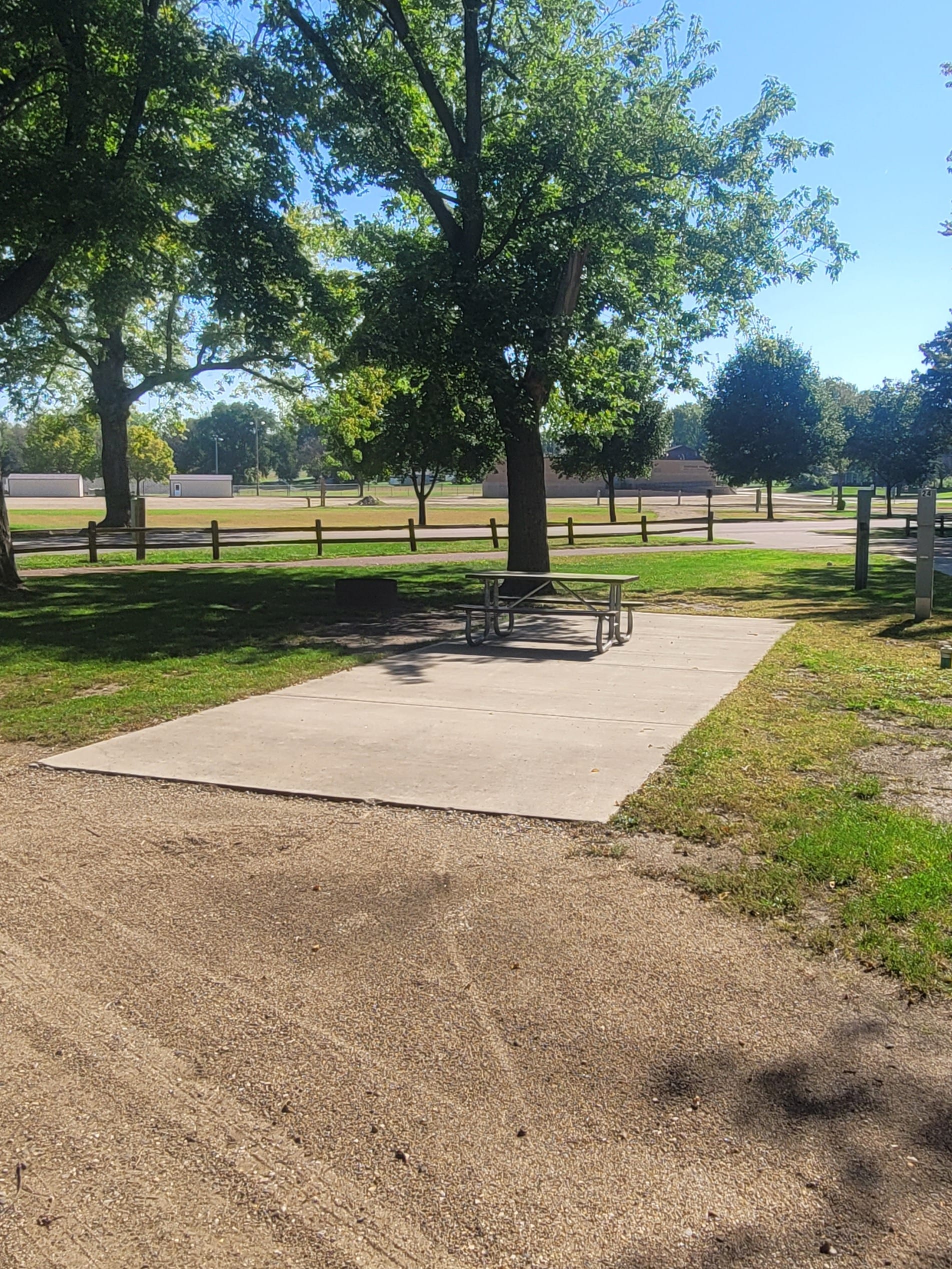 campground site campground site 24 with a gravel path, trees, green grass and a picnic table