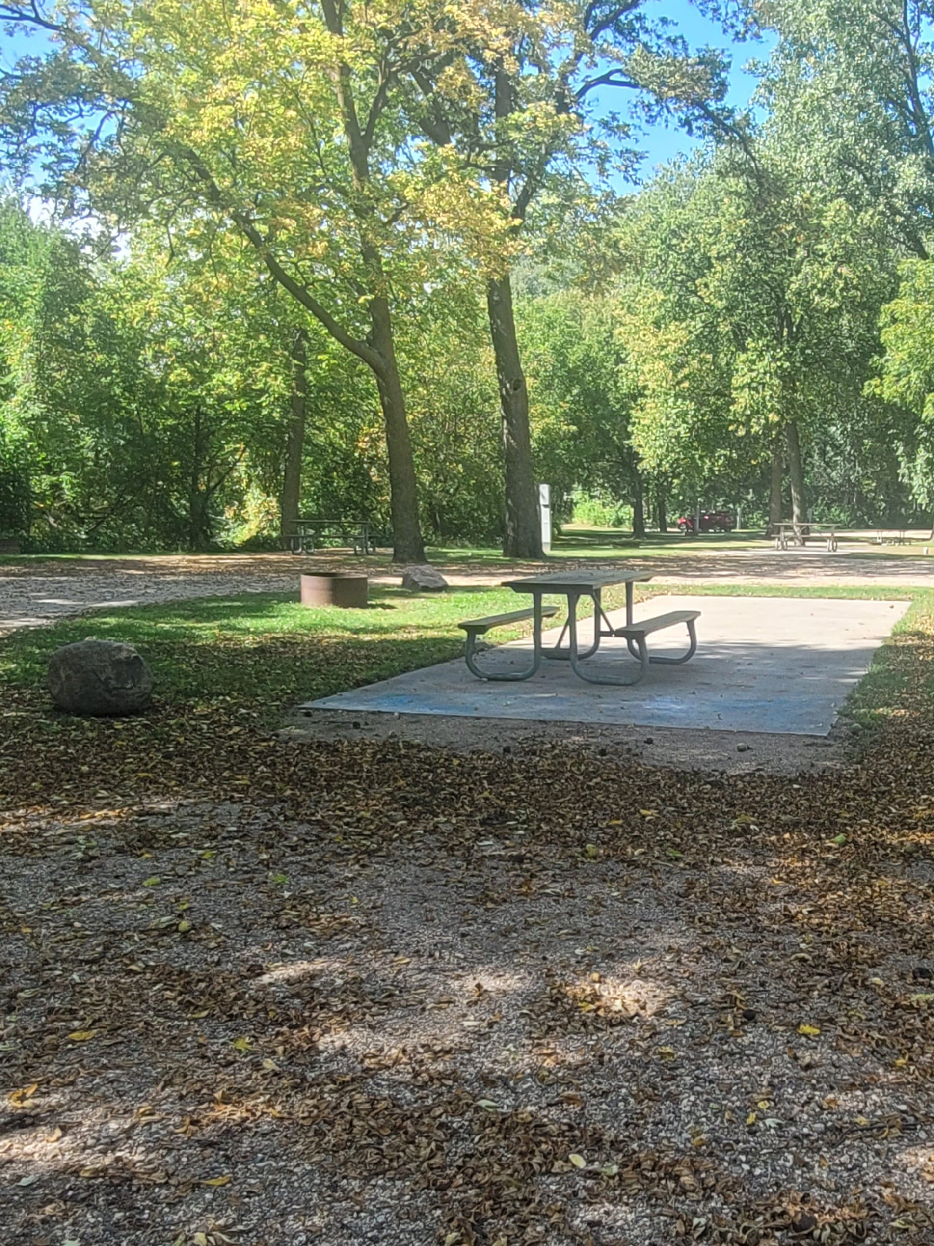 campground site campground site 27 with a gravel path, trees, green grass and a picnic table