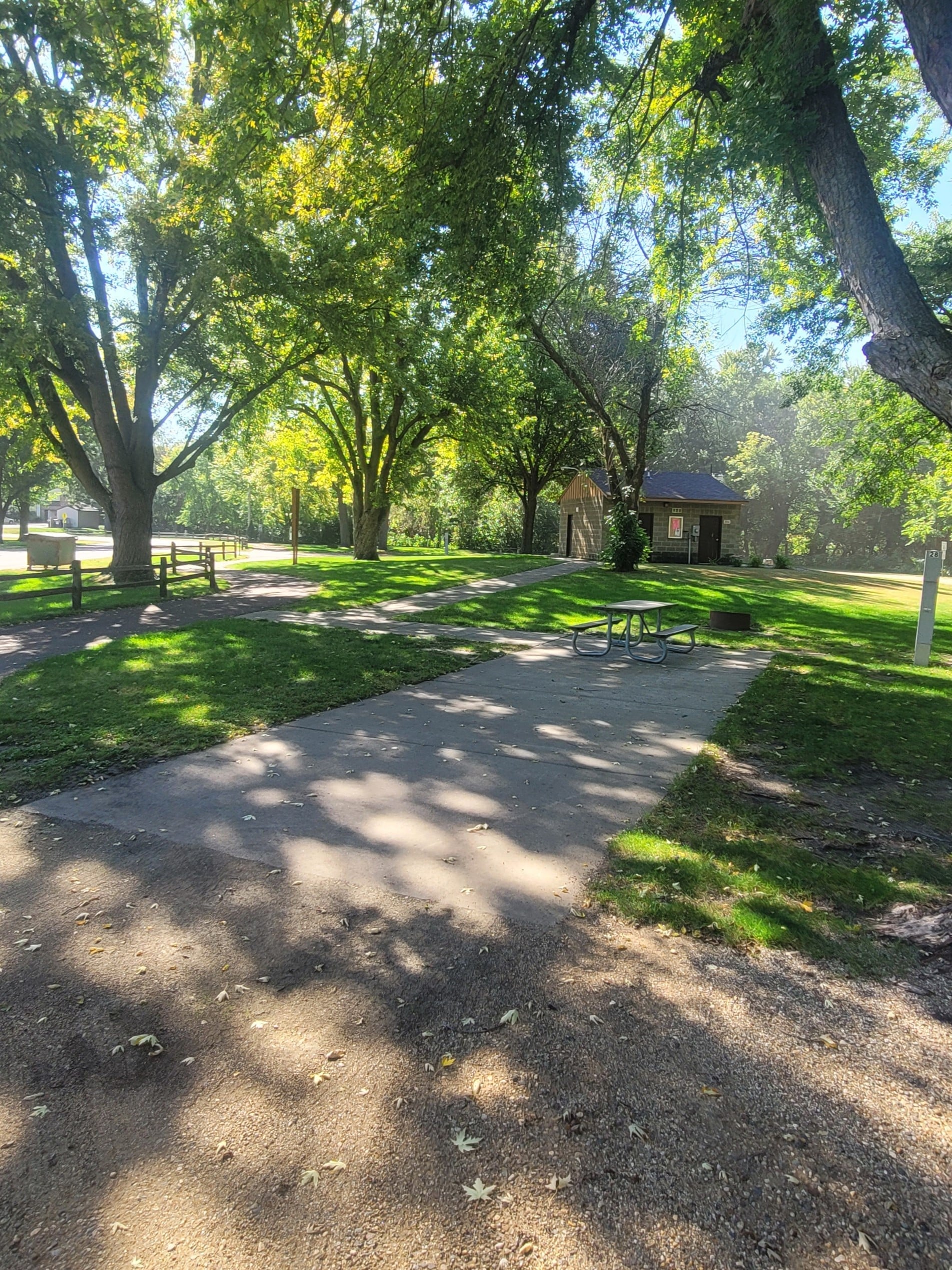 campground site campground site 28 with a gravel path, trees, green grass and a picnic table