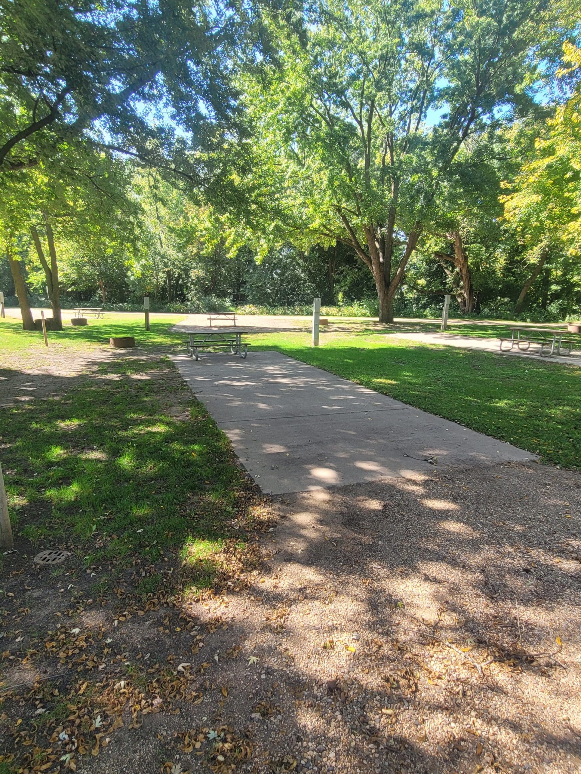 campground site campground site 30 with a gravel path, trees, green grass and a picnic table