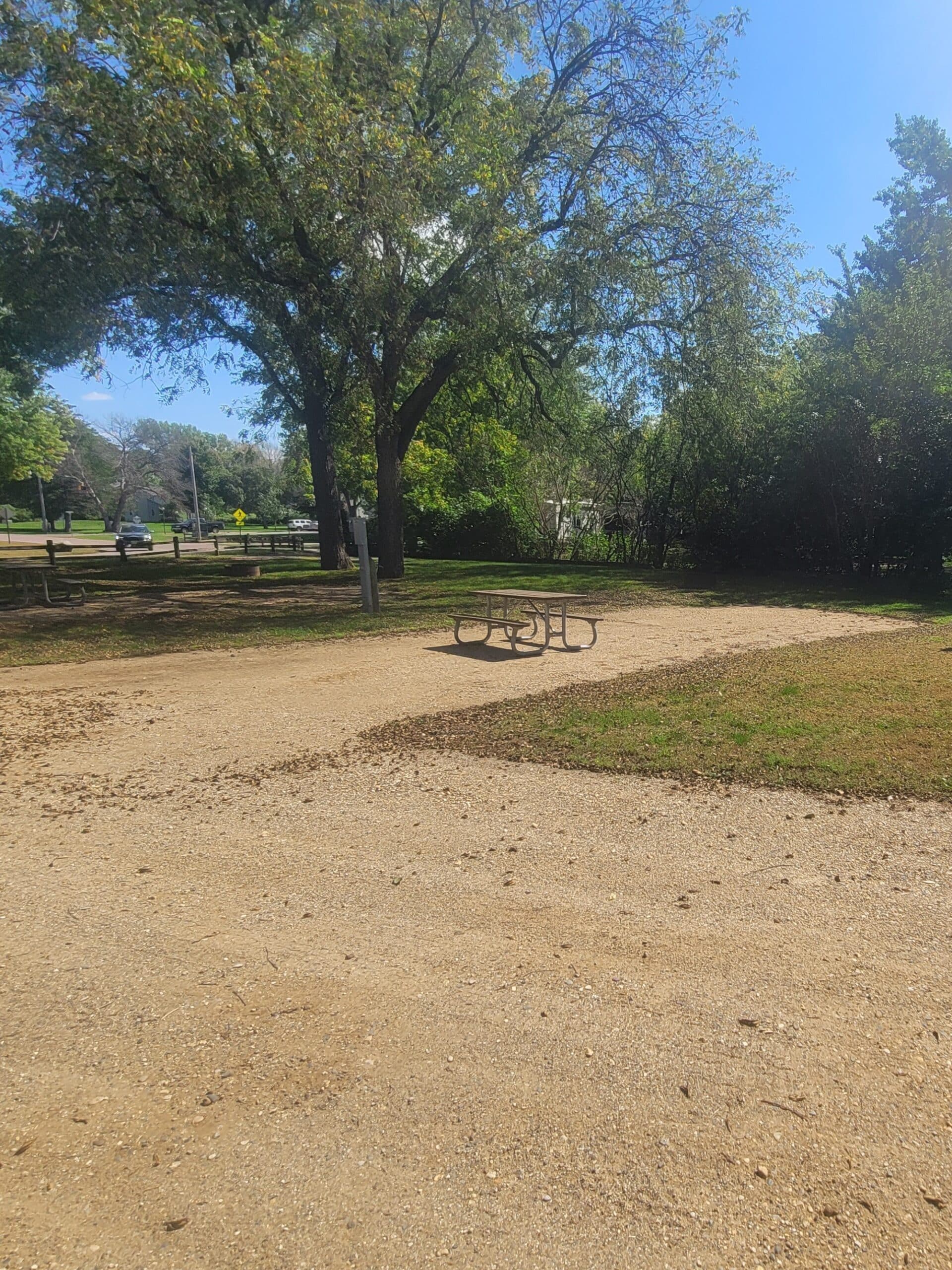 campground site 35 with a gravel path, trees, green grass and a picnic table