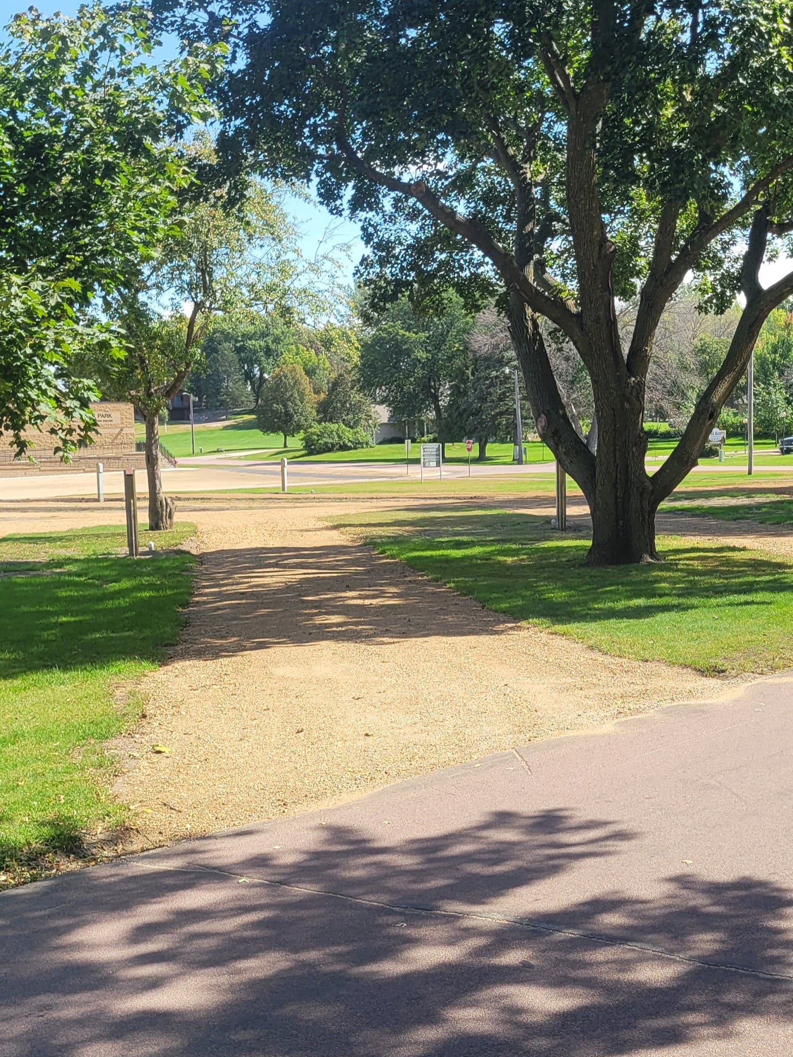 campground site 44 with a gravel path, trees, and green grass
