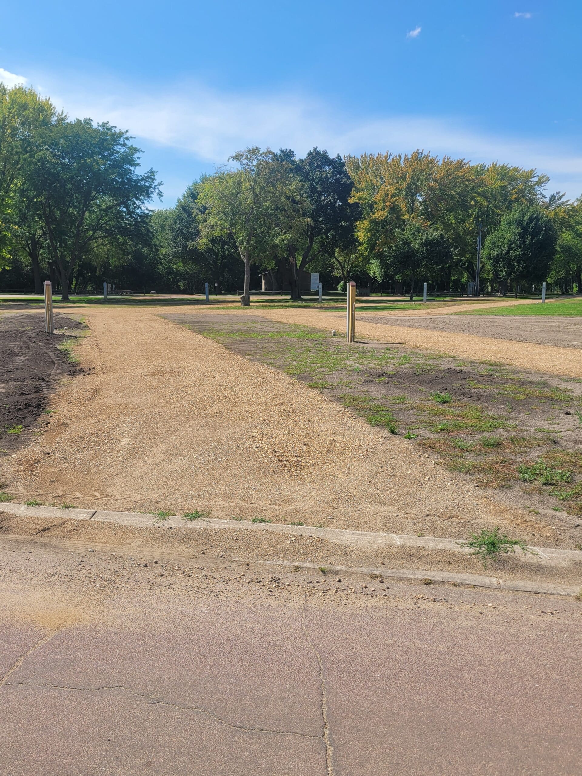 campground site 49 with a gravel path, trees, and green grass