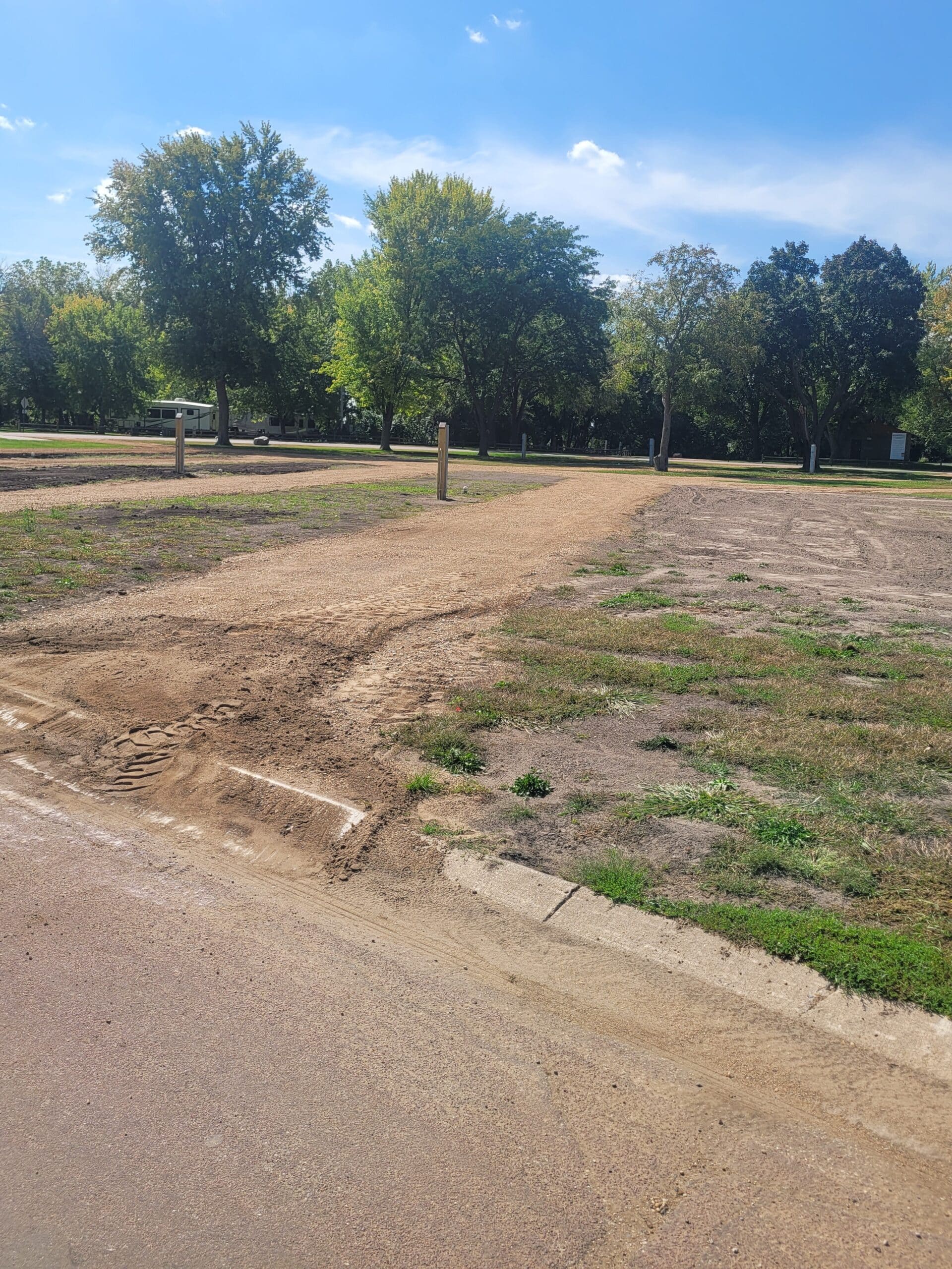 campground site 50 with a gravel path, trees, and green grass