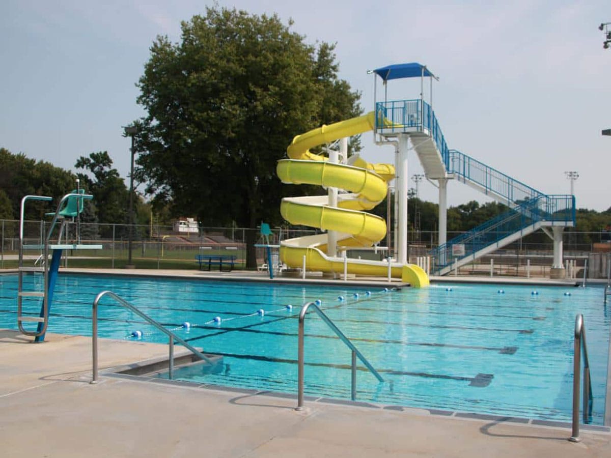 springfield swimming pool filled with clear blue water with a large yellow spiral water slide
