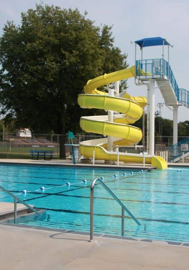 springfield swimming pool filled with clear blue water with a large yellow spiral water slide